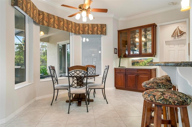 dining space with ceiling fan, light tile patterned floors, and crown molding