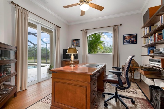 home office with ceiling fan, a wealth of natural light, crown molding, and light hardwood / wood-style floors