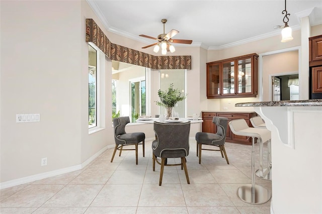 dining room with ornamental molding, a ceiling fan, light tile patterned floors, and baseboards