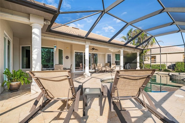 view of patio / terrace featuring outdoor dining space, glass enclosure, and a ceiling fan