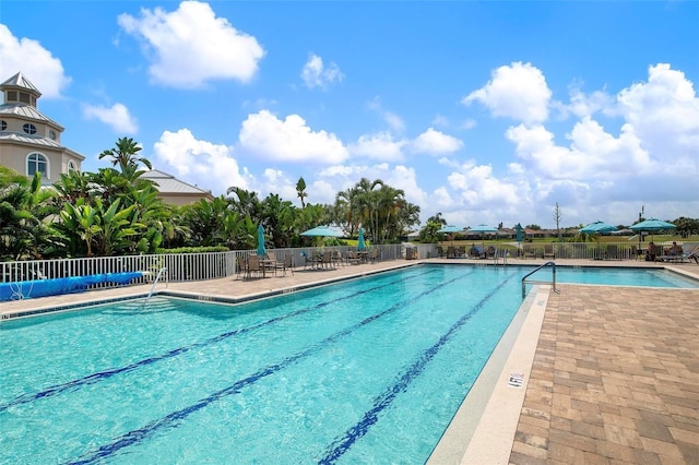 community pool with fence and a patio
