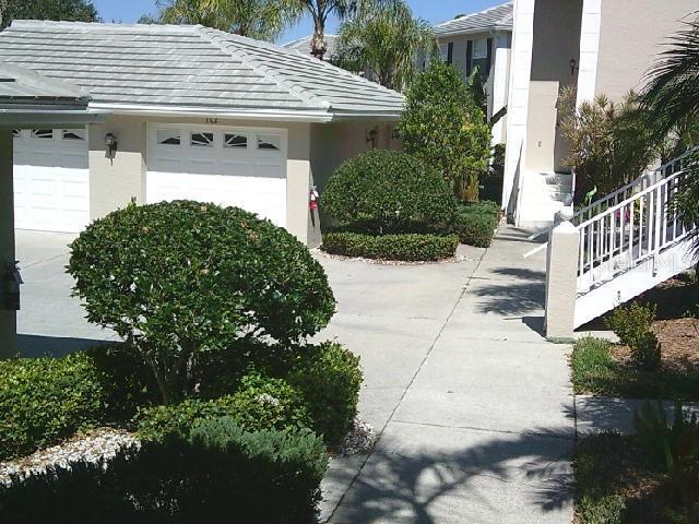 view of side of property with concrete driveway, an attached garage, and stucco siding