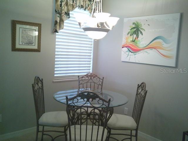 dining area with baseboards and a notable chandelier