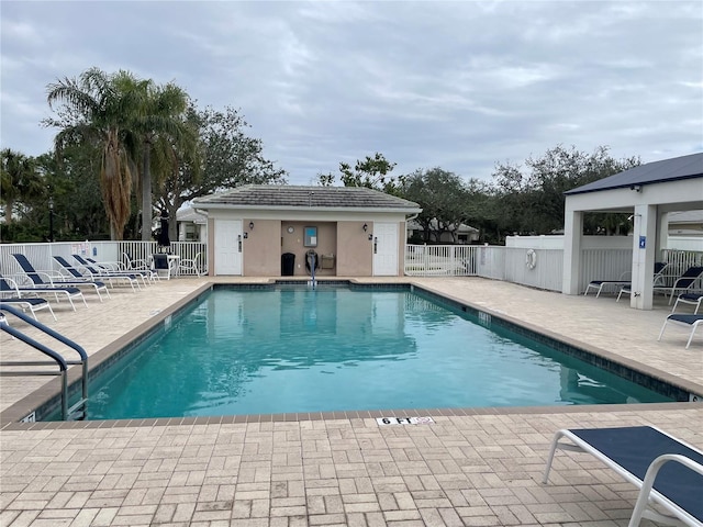 pool with fence and a patio