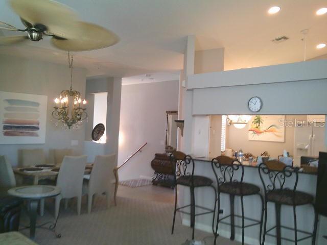 kitchen featuring a breakfast bar area, visible vents, a ceiling fan, and recessed lighting