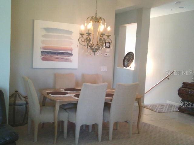 dining room with a notable chandelier and tile patterned floors