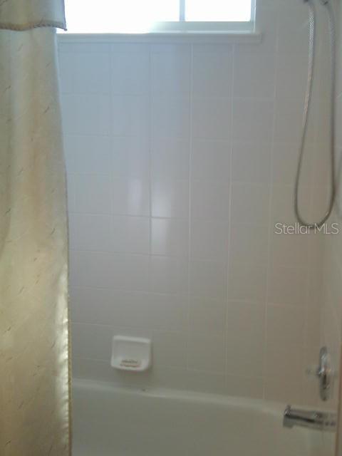 bathroom with shower / bathtub combination with curtain