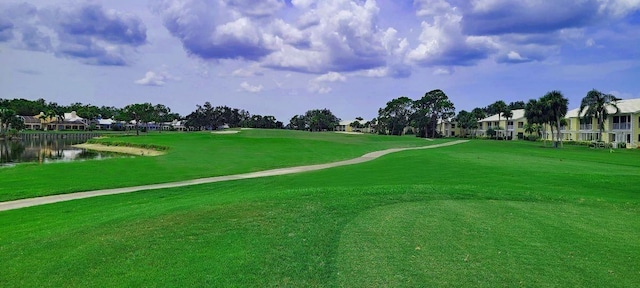 view of property's community featuring view of golf course, a water view, and a yard