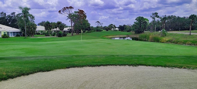 surrounding community featuring view of golf course, a water view, and a lawn