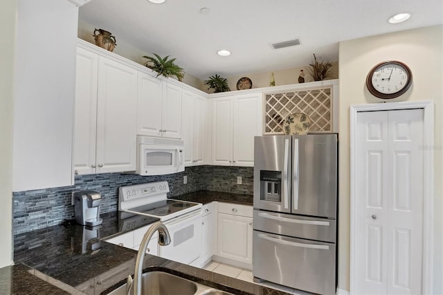 kitchen with light tile patterned flooring, white cabinetry, decorative backsplash, and white appliances