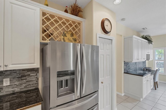 kitchen featuring stainless steel fridge with ice dispenser, light tile patterned flooring, backsplash, and white cabinets