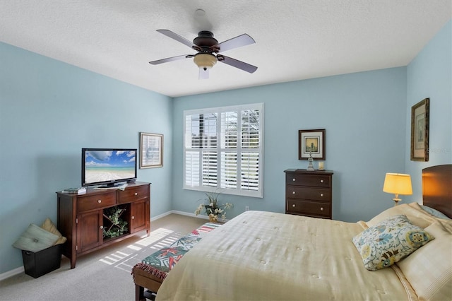 bedroom featuring ceiling fan, light carpet, and a textured ceiling