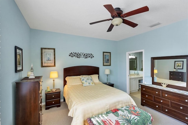 carpeted bedroom with ceiling fan and ensuite bathroom