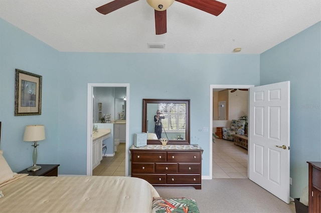 tiled bedroom with ceiling fan and connected bathroom