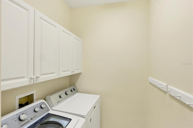 laundry room featuring cabinets and separate washer and dryer