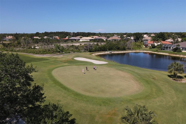 view of property's community with a water view and a lawn