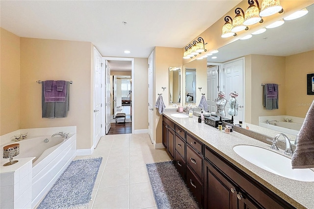 bathroom with vanity, tile patterned flooring, and a washtub