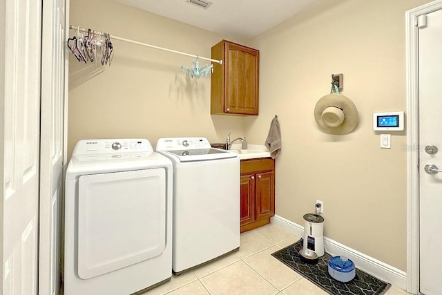 washroom featuring cabinets, light tile patterned floors, washer and clothes dryer, and sink