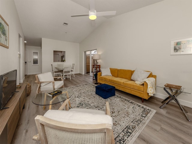 living room featuring ceiling fan, hardwood / wood-style floors, and vaulted ceiling