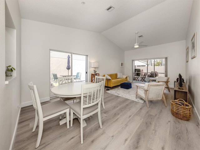 dining space featuring ceiling fan, lofted ceiling, and light wood-type flooring