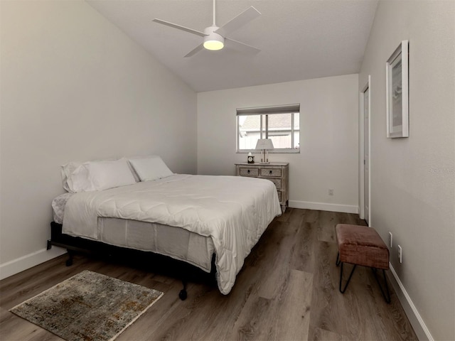 bedroom with ceiling fan, hardwood / wood-style floors, and vaulted ceiling