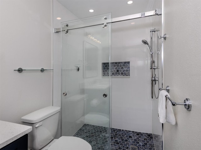 bathroom featuring toilet, an enclosed shower, and vanity