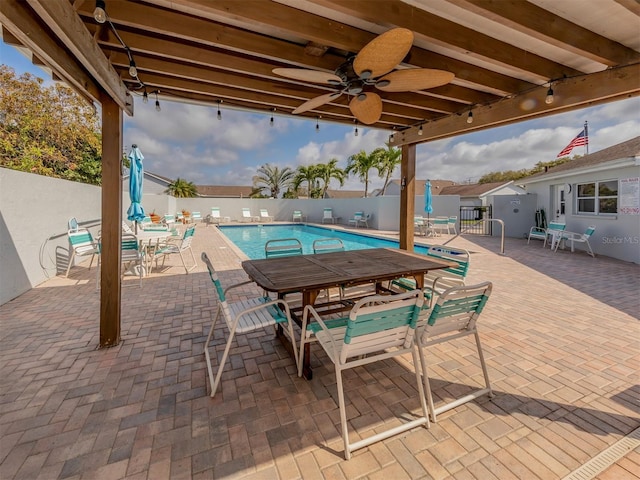 view of swimming pool featuring ceiling fan and a patio area