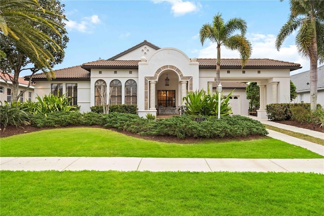 mediterranean / spanish home with a garage and a front yard