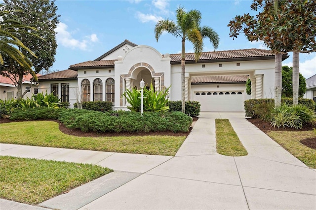 mediterranean / spanish house featuring a garage and a front yard