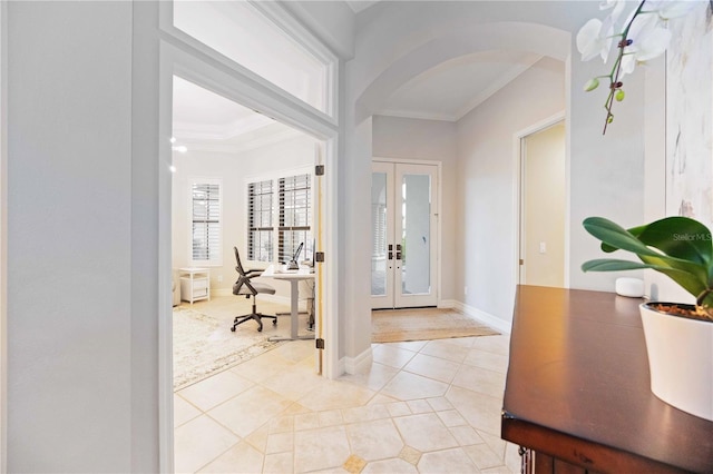 foyer entrance with light tile patterned flooring, ornamental molding, and french doors