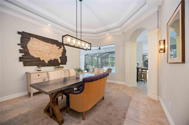 dining area featuring a raised ceiling, light tile patterned flooring, ornamental molding, and decorative columns