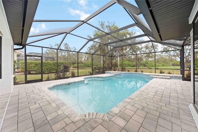 view of pool with glass enclosure and a patio