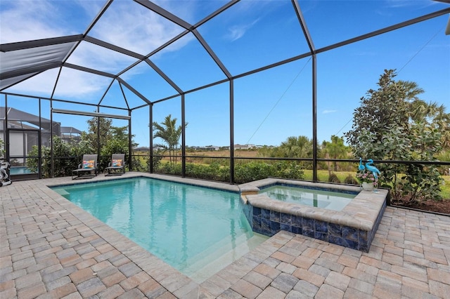 view of pool featuring glass enclosure, an in ground hot tub, and a patio