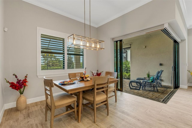 dining area with an inviting chandelier, light hardwood / wood-style flooring, and ornamental molding