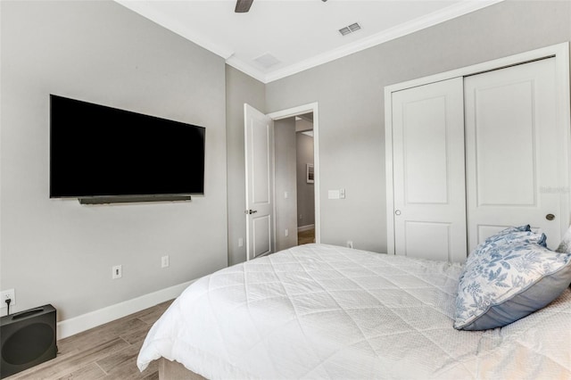 bedroom featuring ceiling fan, wood-type flooring, a closet, and ornamental molding