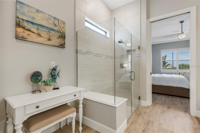 bathroom with hardwood / wood-style floors, walk in shower, and ceiling fan