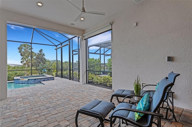 view of patio with an in ground hot tub, a lanai, and ceiling fan