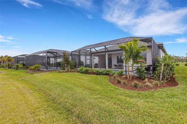 rear view of property with glass enclosure and a yard