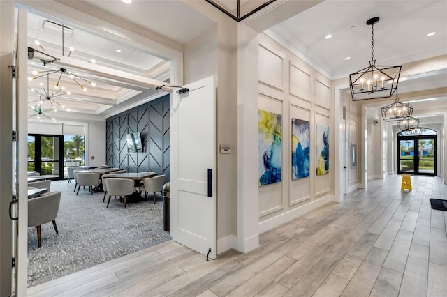 interior space with french doors, beamed ceiling, a notable chandelier, light hardwood / wood-style flooring, and coffered ceiling