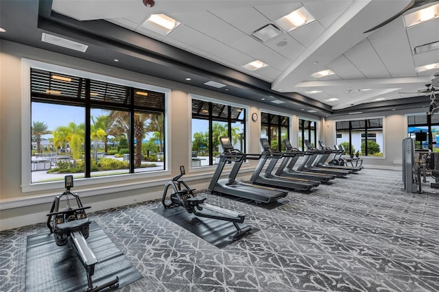 gym with carpet floors and a tray ceiling