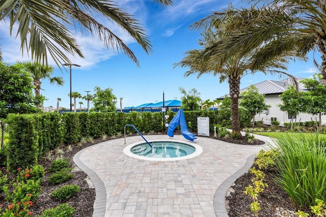 view of swimming pool featuring a patio and a hot tub