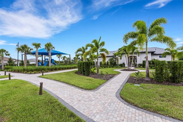 view of property's community with a playground and a yard