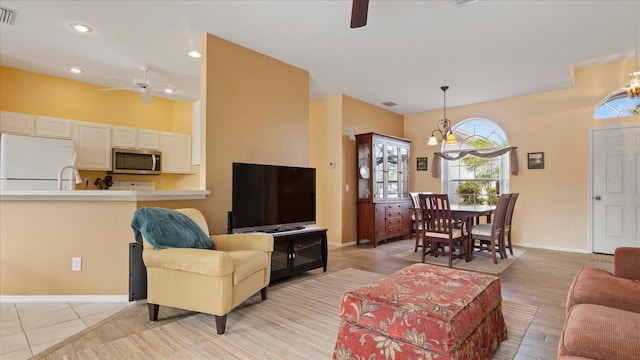 living room featuring ceiling fan with notable chandelier