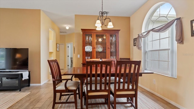 dining area featuring a notable chandelier and light hardwood / wood-style floors