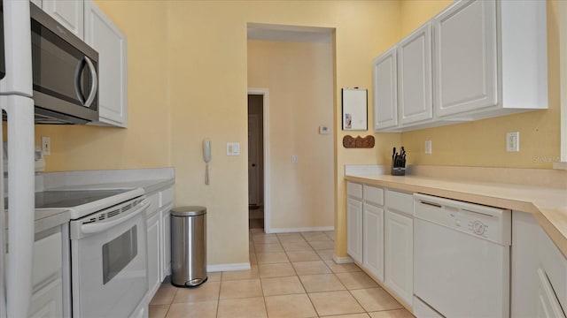 kitchen with light tile patterned flooring, white cabinets, and white appliances