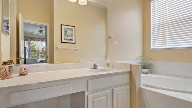 bathroom with a relaxing tiled tub, ceiling fan, and vanity