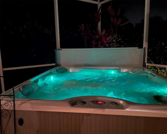 pool at twilight featuring a hot tub