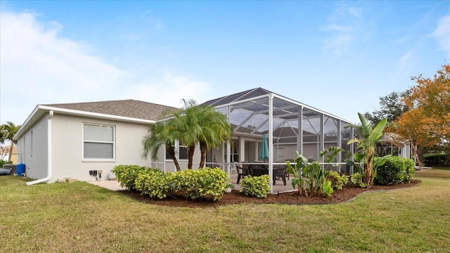 rear view of house with a lanai and a lawn