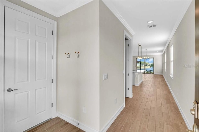 hallway featuring light hardwood / wood-style flooring and crown molding