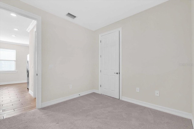 spare room with light carpet and ornamental molding